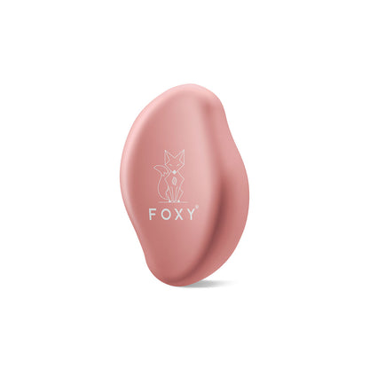 Light pink, Matte, Oval-shaped hair removal tool with a stylized fox logo and the word FOXY printed on it.