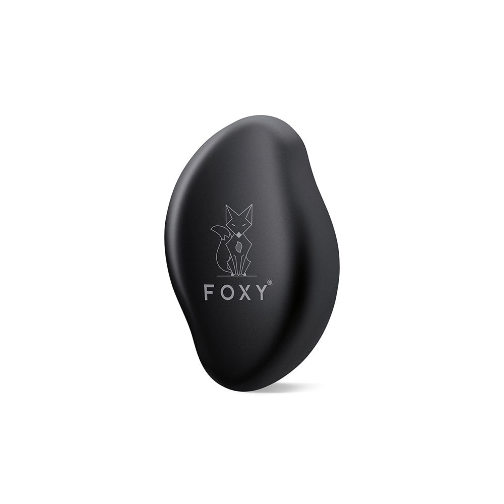 Black, Matte, Oval-shaped hair removal tool with a stylized fox logo and the word FOXY printed on it.
